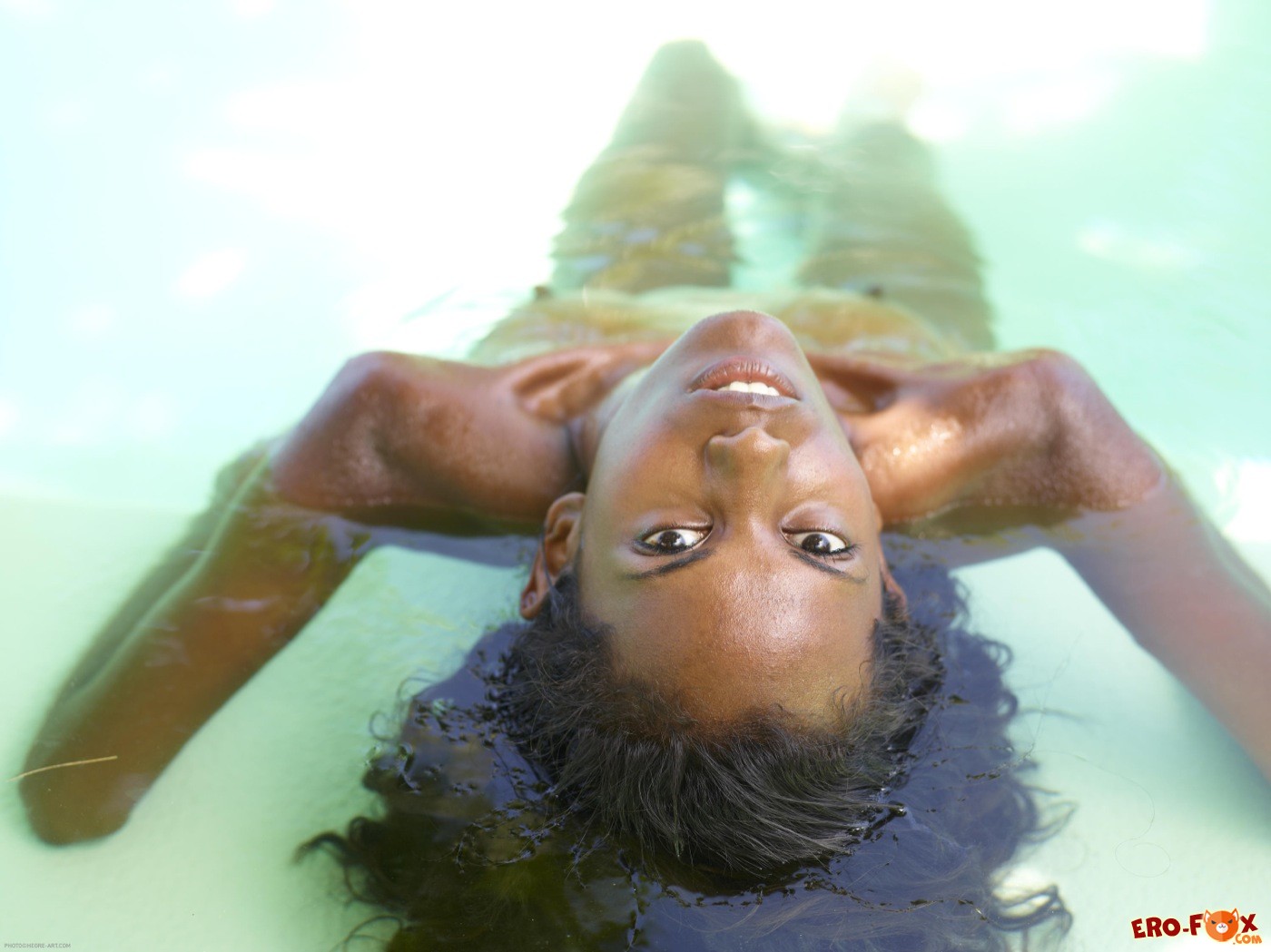 Тощая негритянка голая купается в бассейне - фото